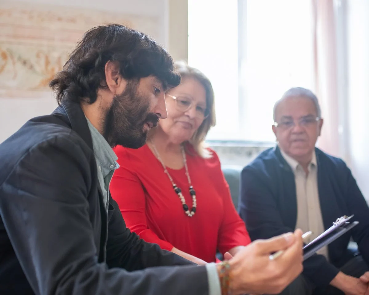 A consultant and a couple reviewing paperwork together.