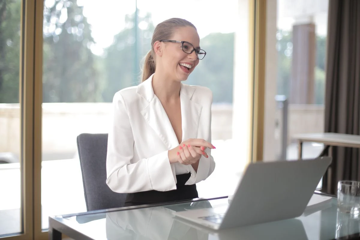 A smiling professional at her laptop.
